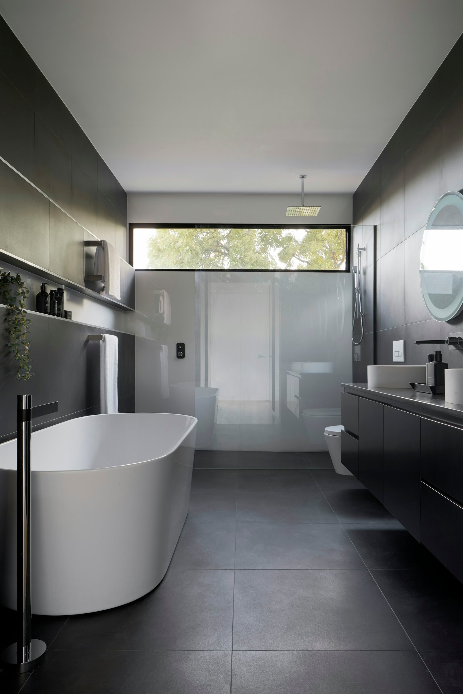 Dark contemporary bathroom with freestanding tub. Stock design inspiration.